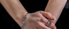 Loretana model hands crossed with stack of 925 silver rings and bracelet, daily silver care guide. Hand-finished hallmarked piece from Kaunas.