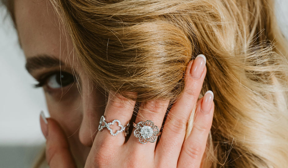 Loretana model intimate hand-to-hair pose with sterling silver filigree rings and bracelet, complete interchangeable jewelry guide. Kaunas.