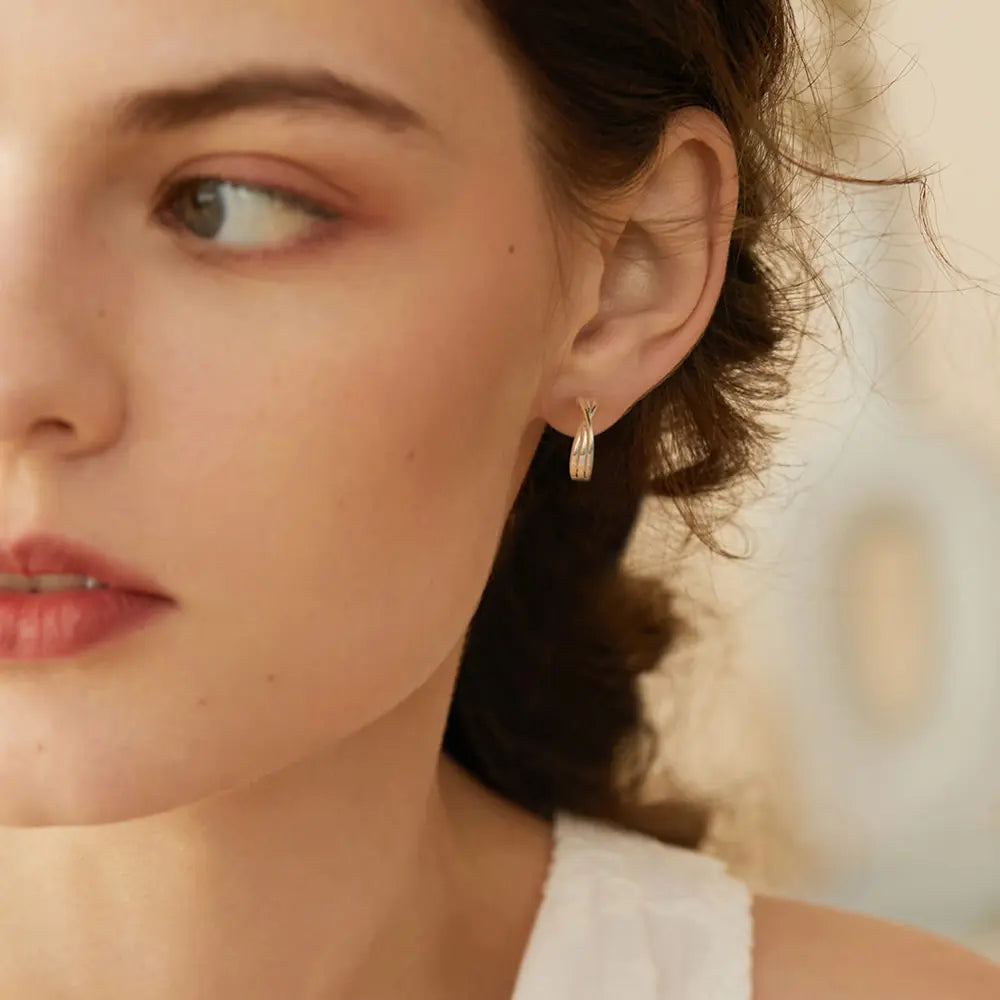 Close up of the 14K Gold Minimalist Hoops highlighting the secure clasp and the 14K gold-plated hallmark.