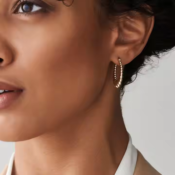 Woman wearing the 14K Gold Thick Twisted Hoops as a bold, architectural statement for a sophisticated everyday look.