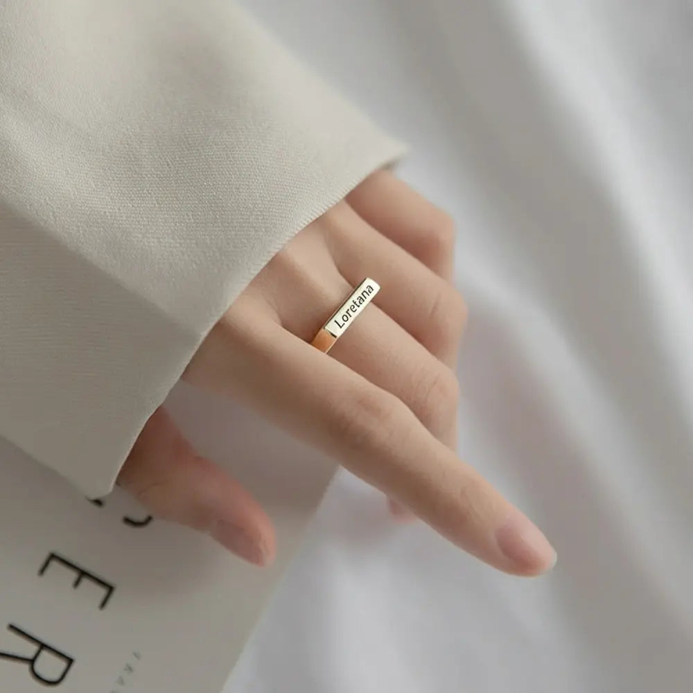 Close-up of a model's hand wearing the personalized 14K gold-plated engravable rectangle ring.