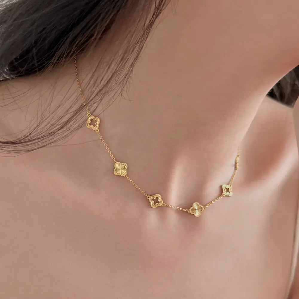 Gold necklace with floral pendants on a person's neck