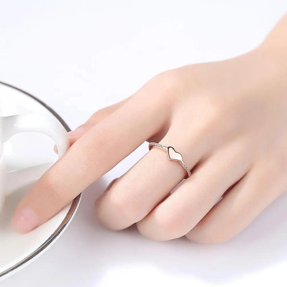 Angled view of the gold heart ring on a hand model, capturing the polished band and heart cut zirconia. Hallmarked Loretana piece, hand-finished in Kaunas.