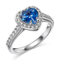 Macro detail of the heart-cut AAAAA blue sapphire-tone zirconia in the 925 sterling silver ring, rhodium-plated band reflecting light around the prong setting. Hallmarked Loretana piece, hand-finished in Kaunas.