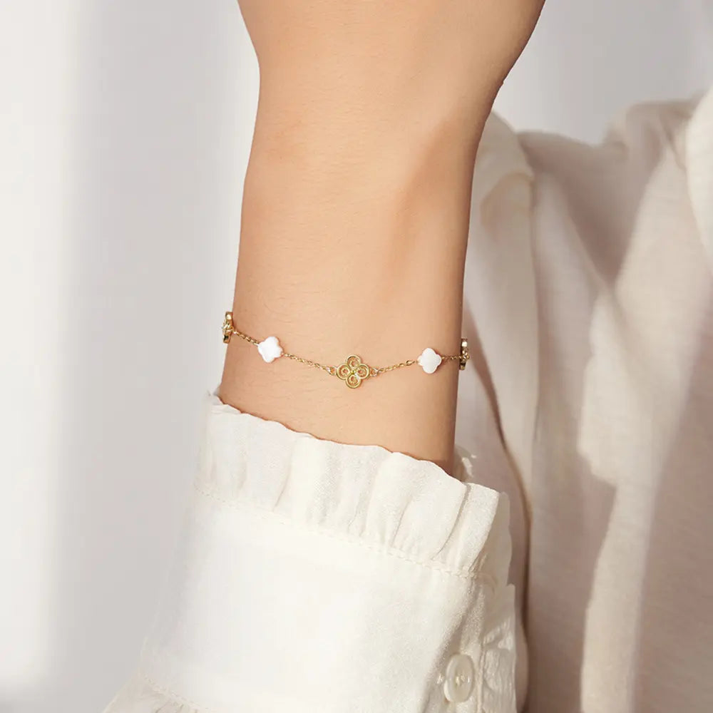 Close up of 14K gold clover bracelet showing iridescent shell pearl inlay