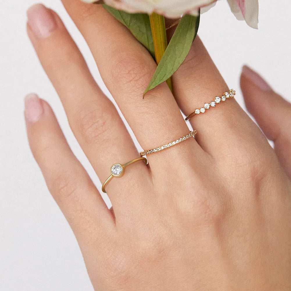 Hand model wearing the gold eternity band stacked with a plain band for a minimalist bridal look. Hallmarked Loretana piece, hand-finished in Kaunas.
