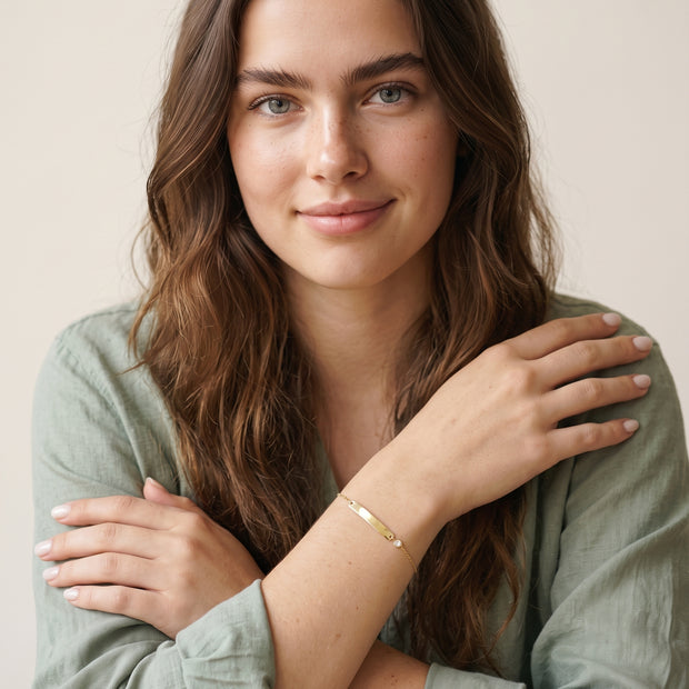 Model wearing the Engraved Curved Bar Bracelet, CZ in 14K gold-plated 925 sterling silver