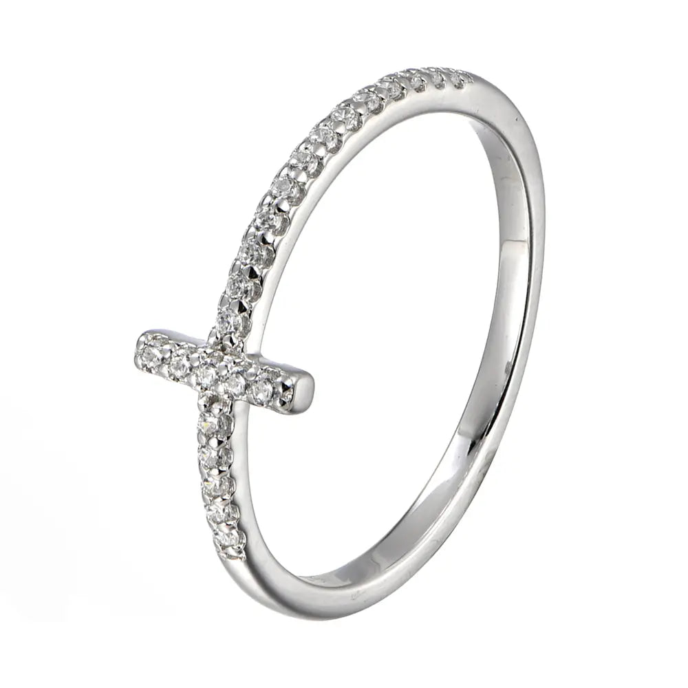 Hand model wearing the silver cross zirconia ring in 925 sterling silver with rhodium plating, slim cross motif resting flat against the finger in soft daylight. Hallmarked Loretana piece, hand-finished in Kaunas.