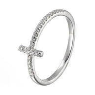 Hand model wearing the silver cross zirconia ring in 925 sterling silver with rhodium plating, slim cross motif resting flat against the finger in soft daylight. Hallmarked Loretana piece, hand-finished in Kaunas.