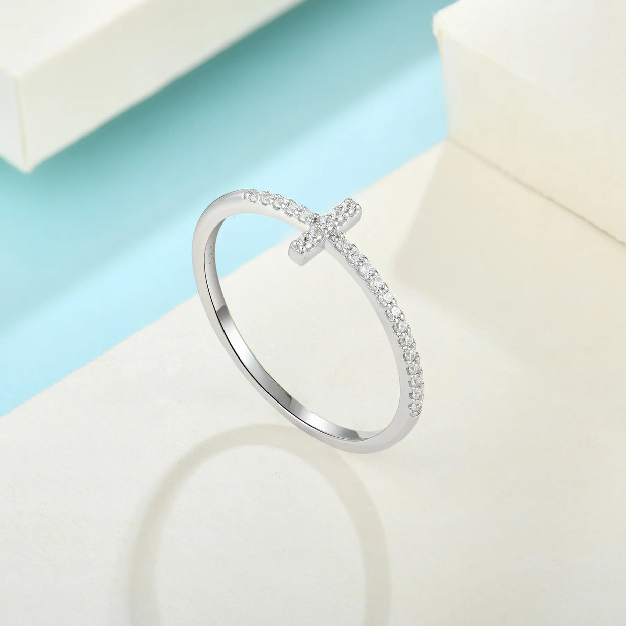 Studio overhead shot of the rhodium-plated 925 sterling silver cross ring on a clean white background, full band visible with AAAAA cubic zirconia. Hallmarked Loretana piece, hand-finished in Kaunas.