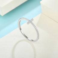 Studio overhead shot of the rhodium-plated 925 sterling silver cross ring on a clean white background, full band visible with AAAAA cubic zirconia. Hallmarked Loretana piece, hand-finished in Kaunas.