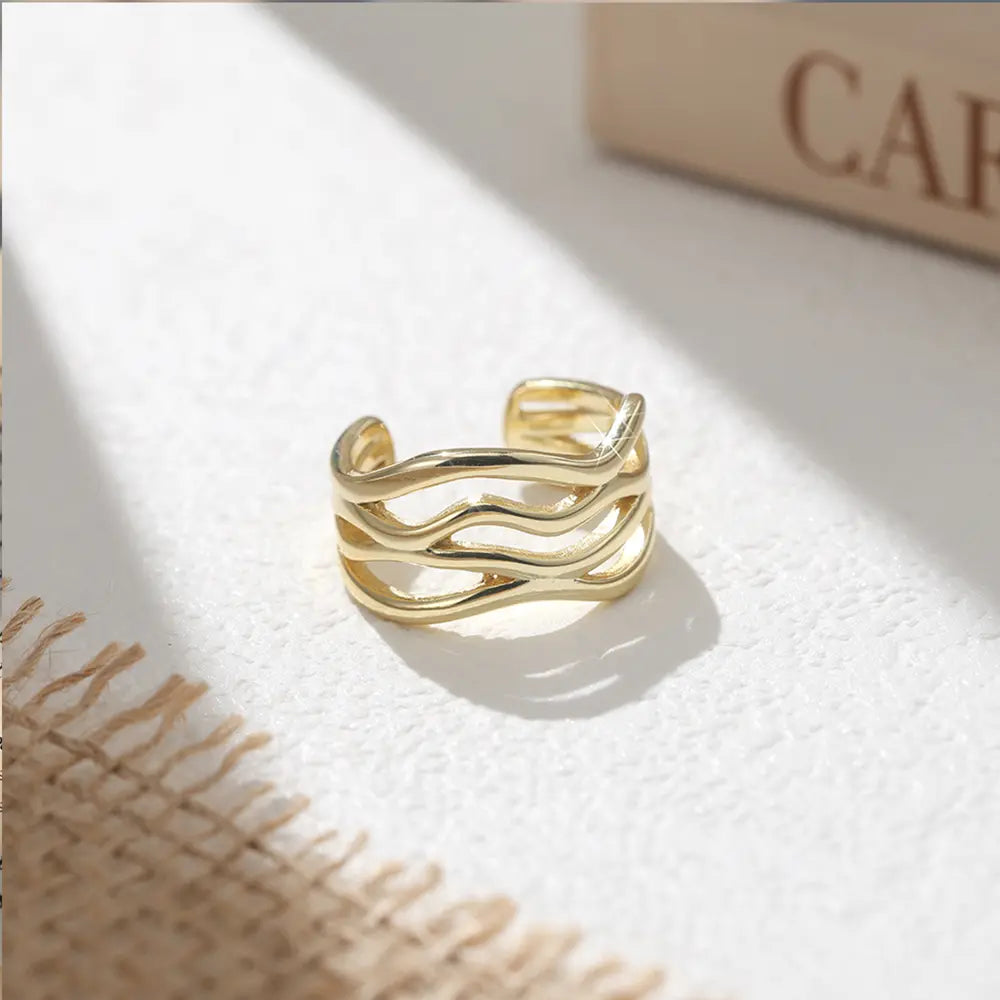 Top view of the twisted wave adjustable ring on white, 925 sterling silver with 14K gold plating and polished sculptural finish. Hallmarked Loretana piece, hand-finished in Kaunas.
