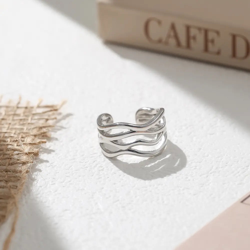 Hand wearing the silver twisted wave adjustable ring in 925 sterling silver with rhodium plating, styled for minimalist daily stacking. Hallmarked Loretana piece, hand-finished in Kaunas.