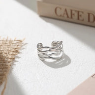 Hand wearing the silver twisted wave adjustable ring in 925 sterling silver with rhodium plating, styled for minimalist daily stacking. Hallmarked Loretana piece, hand-finished in Kaunas.